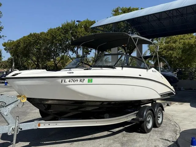 Slide: The Image of 2018 Yamaha Boats SX210 on trailer, parked outdoors under a canopy. - 14