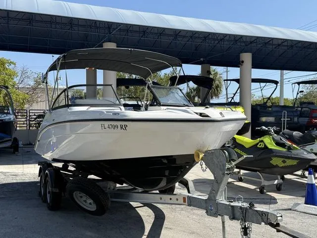 Slide: The Image of 2018 Yamaha Boats SX210 on trailer in parking lot, cloudy sky background. - 4