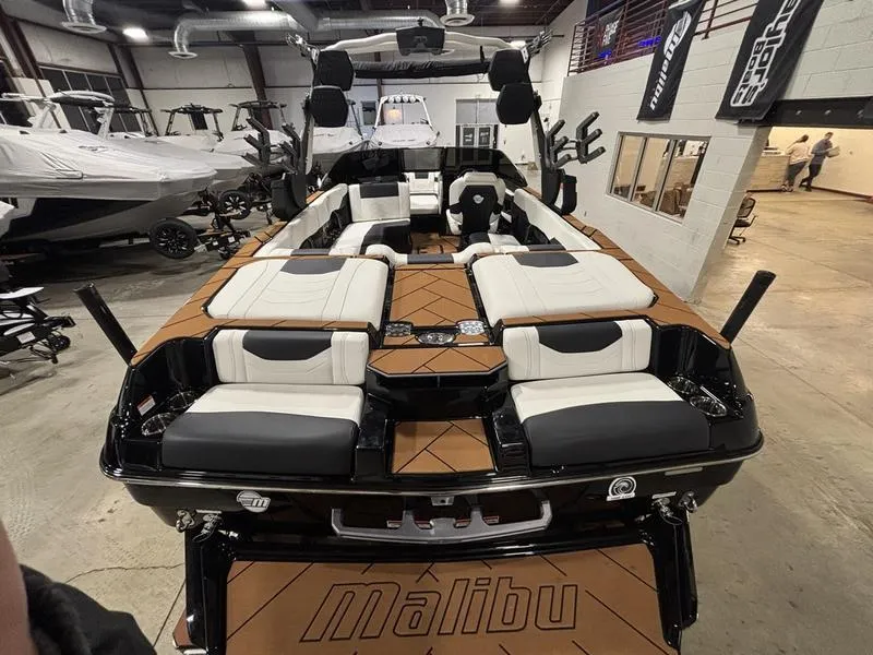 Slide: The Image of 2025 Malibu 23 LSV boat interior with luxurious seating in a showroom. - 10
