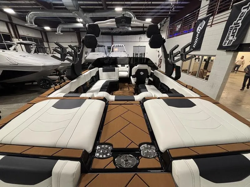 Slide: The Image of 2025 Malibu 23 LSV boat interior with luxurious seating in a showroom. - 11