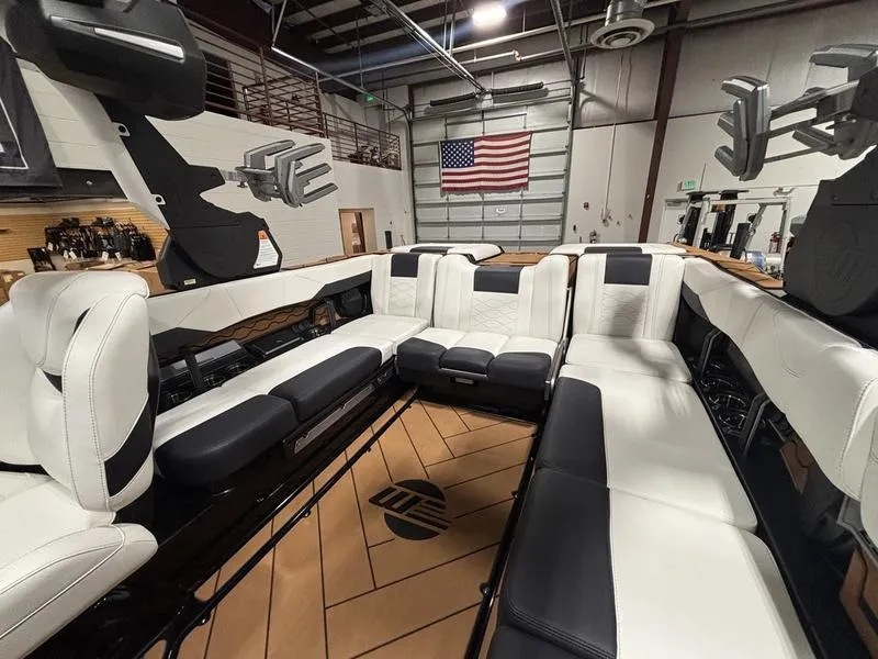Slide: The Image of 2025 Malibu 23 LSV boat interior with luxurious seating in a showroom. - 17