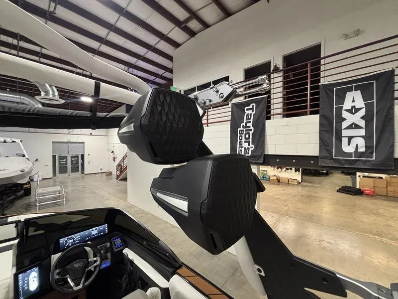 Slide: The Image of 2025 Malibu 23 LSV boat interior with advanced dashboard and sound system in showroom. - 19