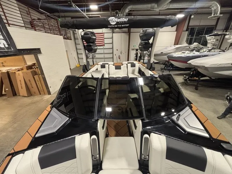 Slide: The Image of 2025 Malibu 23 LSV boat interior in showroom, featuring sleek design and modern seating. - 20