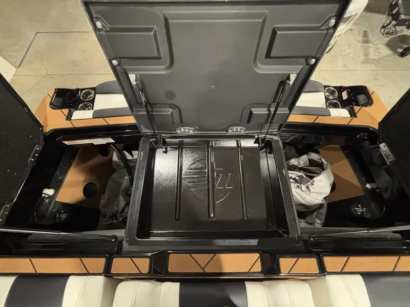 Slide: The Image of 2025 Malibu 23 LSV boat interior storage compartment open, showcasing spacious design. - 24