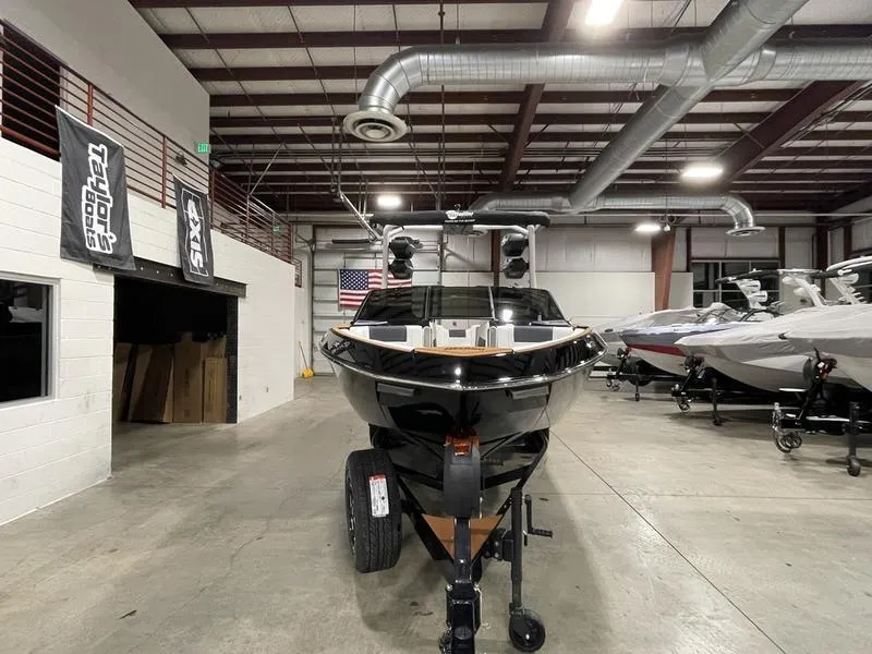 Slide: The Image of 2025 Malibu 23 LSV boat in showroom, front view, industrial setting. - 3
