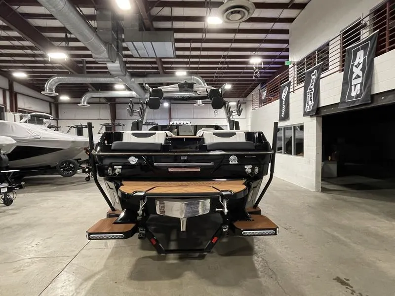 Slide: The Image of 2025 Malibu 23 LSV boat in a showroom, rear view with modern design features. - 8