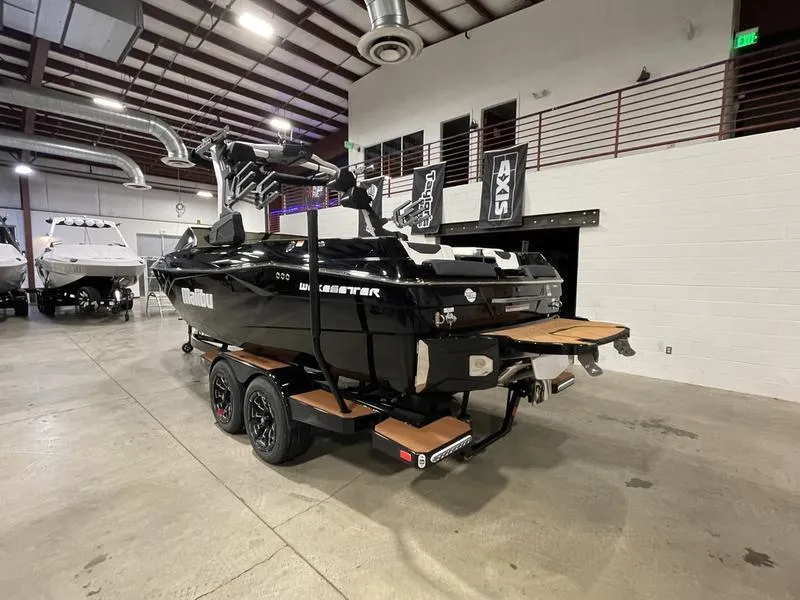 Slide: The Image of 2025 Malibu 23 LSV boat in showroom, black exterior, on trailer. - 9