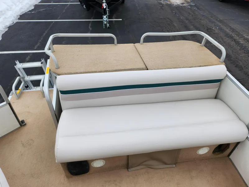 Slide: The Image of Sweetwater 180 pontoon boat interior, beige seating, 2000 model, parked on asphalt. - 12