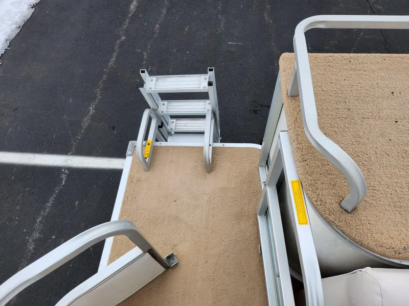 Slide: The Image of Sweetwater 180 boat deck with beige carpet and metal railings, 2000 model. - 13