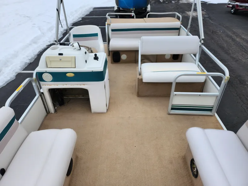 Slide: The Image of 2000 Sweetwater 180 pontoon boat interior with beige seating and steering console. - 9