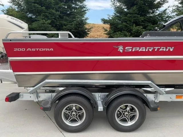 The Image of 2025 Spartan 200 Astoria boat on trailer, red and silver design. - 0