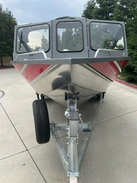 Slide: The Image of 2025 Spartan 200 Astoria boat on trailer, front view, outdoors. - 10