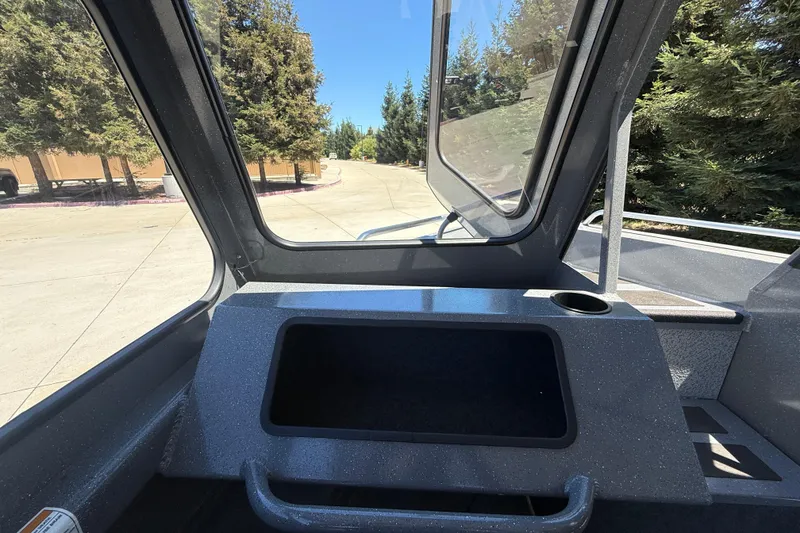 Slide: The Image of Interior view of 2025 Spartan 200 Astoria boat with open window and trees outside. - 25