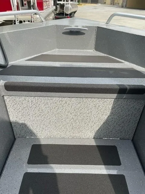 Slide: The Image of 2025 Spartan 200 Astoria boat interior with gray textured flooring and seating. - 2