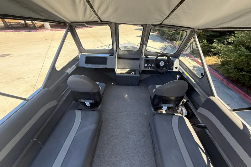 Slide: The Image of Interior of 2025 Spartan 200 Astoria boat with seating and steering wheel. - 29