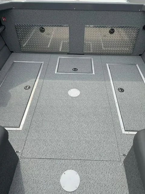 Slide: The Image of 2025 Spartan 200 Astoria boat interior with storage compartments and diamond plate accents. - 3