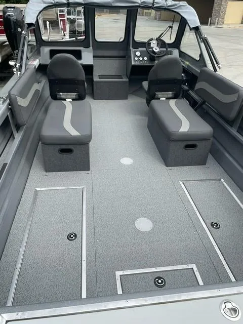 Slide: The Image of 2025 Spartan 200 Astoria boat interior with gray seating and storage compartments. - 9