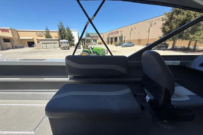 Slide: The Image of Interior view of 2025 Spartan 200 Astoria boat with seating, parked near stores. - 18