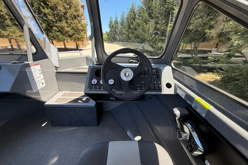 Slide: The Image of Interior view of 2025 Spartan 200 Astoria boat cockpit with steering wheel and controls. - 19