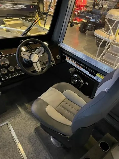 Slide: The Image of 2023 Spartan 215 Athens boat interior with steering wheel and captain's chair. - 15