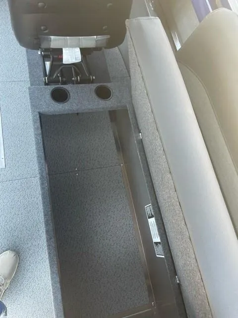 Slide: The Image of Interior of 2025 Spartan 240 Maximus Pro with storage compartment and cup holders. - 14