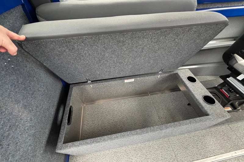 Slide: The Image of Storage compartment in 2025 Spartan 240 Maximus Pro boat with cup holders and gray upholstery. - 29
