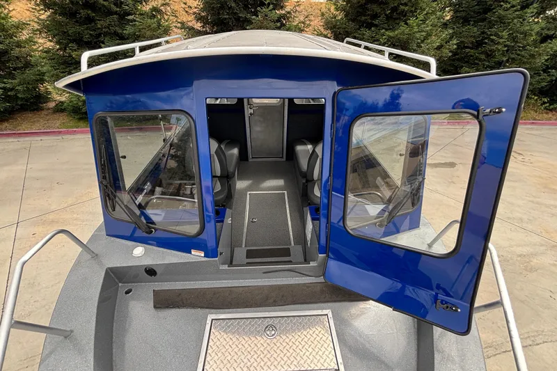 Slide: The Image of 2025 Spartan 240 Maximus Pro boat with open cabin doors, showcasing interior seating. - 13