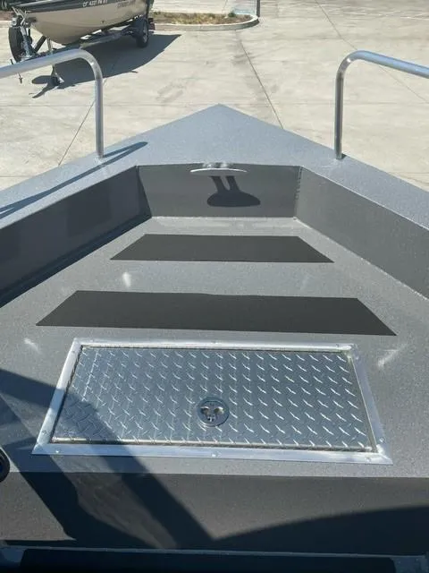 Slide: The Image of 2025 Spartan 240 Maximus Pro boat deck with diamond plate hatch and railings. - 6