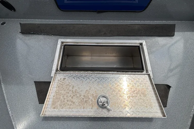 Slide: The Image of Open storage compartment on 2025 Spartan 240 Maximus Pro boat, featuring a metallic finish. - 37