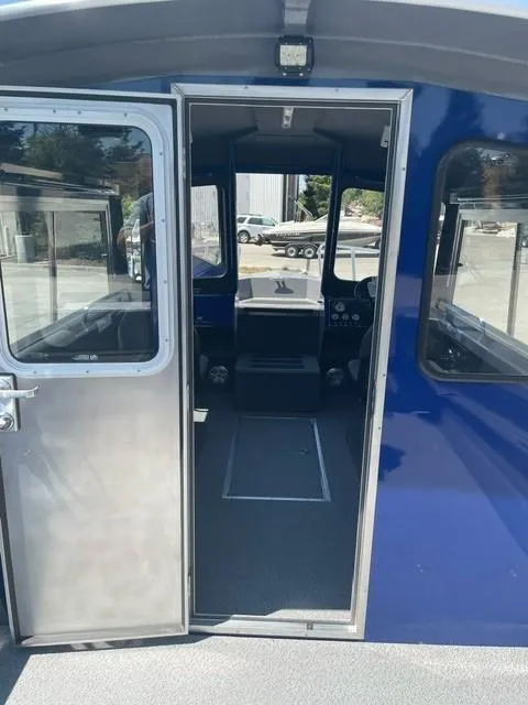 Slide: The Image of 2025 Spartan 240 Maximus Pro boat interior with open door, showcasing cockpit and controls. - 8