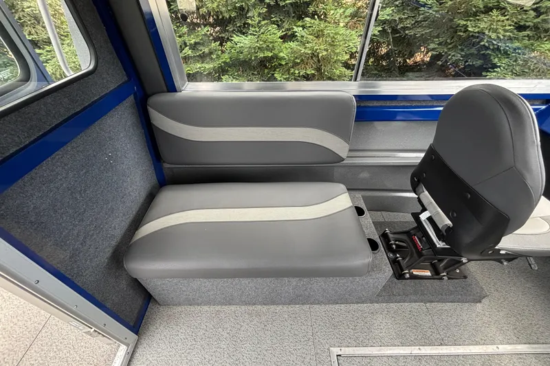 Slide: The Image of Interior seating of 2025 Spartan 240 Maximus Pro boat, featuring gray and blue upholstery. - 21