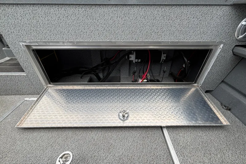 Slide: The Image of Open storage compartment in 2025 Spartan 240 Maximus Pro boat, showcasing interior wiring. - 26