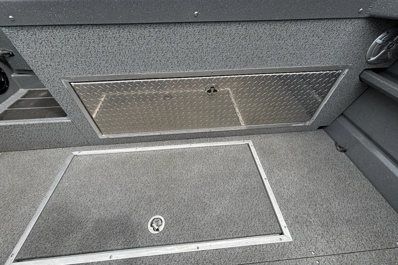 Slide: The Image of Interior of 2025 Spartan 240 Maximus Pro boat, featuring storage compartments and textured flooring. - 25