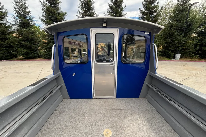 Slide: The Image of 2025 Spartan 240 Maximus Pro boat with blue cabin and spacious deck. - 19