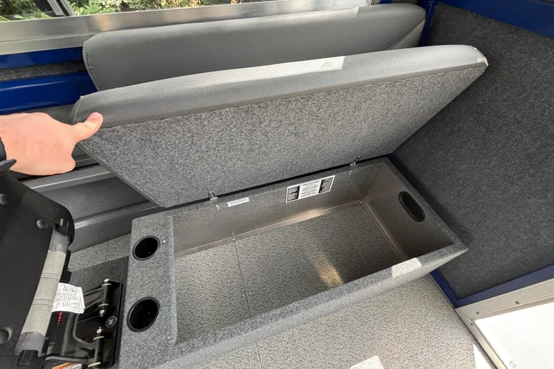 Slide: The Image of Storage compartment in 2025 Spartan 240 Maximus Pro with cup holders and gray upholstery. - 23