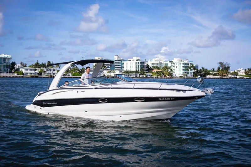 Slide: The Image of 2006 Crownline 320 LS boat cruising on a sunny day near waterfront buildings. - 0