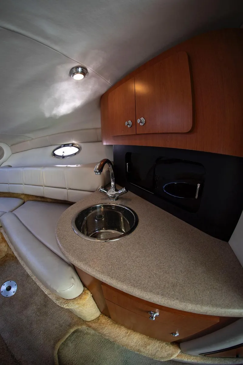 Slide: The Image of 2006 Crownline 320 LS interior with sink and wooden cabinetry. - 11