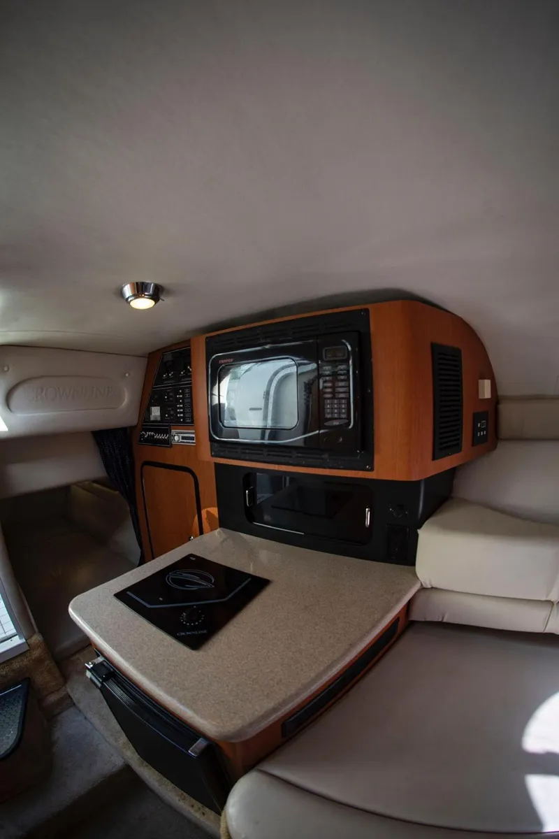Slide: The Image of Interior of 2006 Crownline 320 LS boat with kitchenette and seating area. - 12