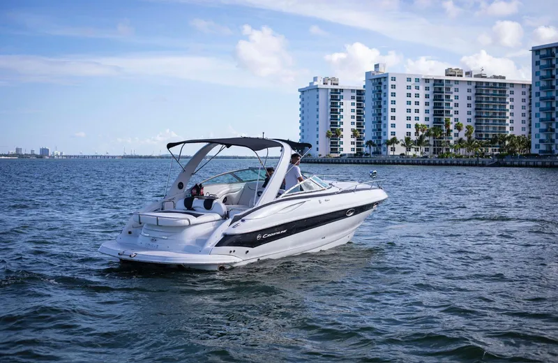 Slide: The Image of 2006 Crownline 320 LS boat cruising near waterfront buildings. - 2