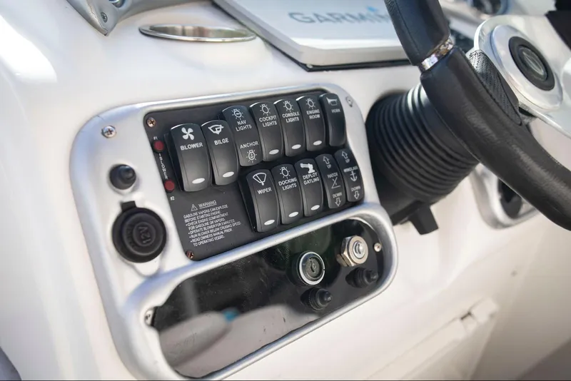 Slide: The Image of Control panel of a 2006 Crownline 320 LS boat with various switches and steering wheel. - 23