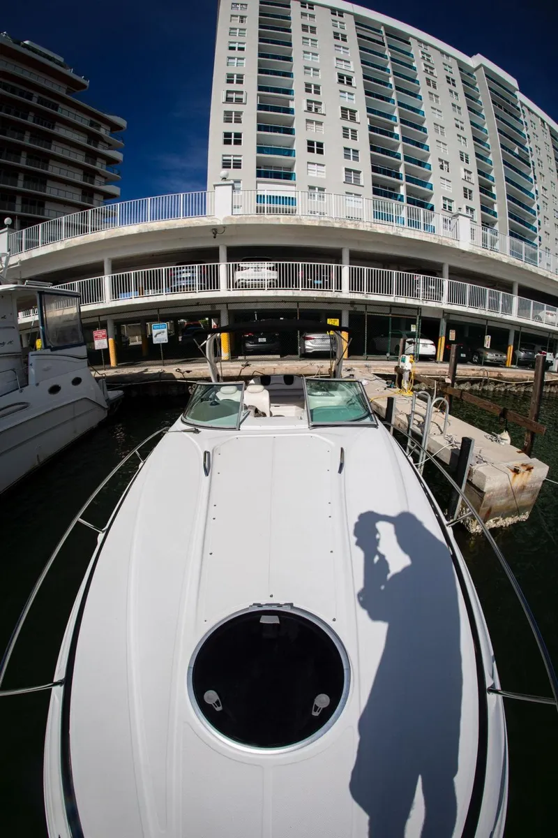 Slide: The Image of 2006 Crownline 320 LS boat docked near a tall building. - 27