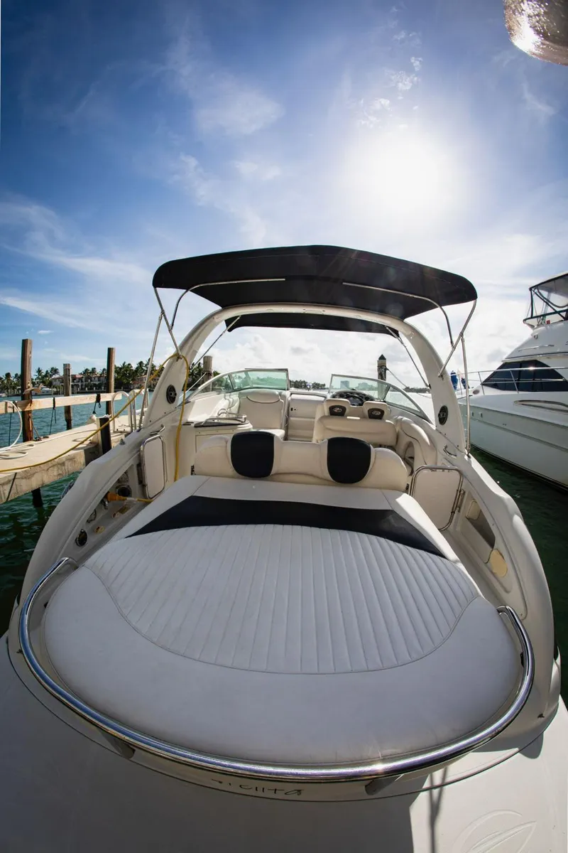 Slide: The Image of 2006 Crownline 320 LS boat with spacious deck, docked under clear blue sky. - 28