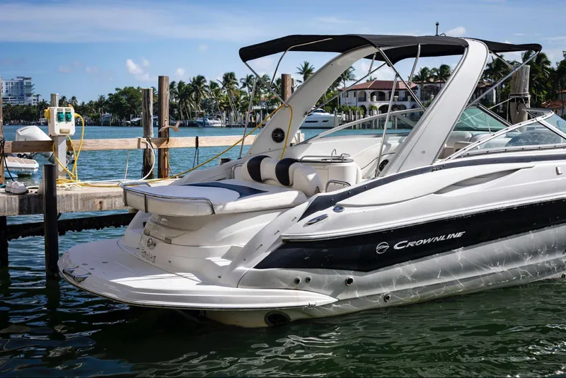 Slide: The Image of 2006 Crownline 320 LS boat docked in a marina, featuring sleek design and spacious seating. - 4