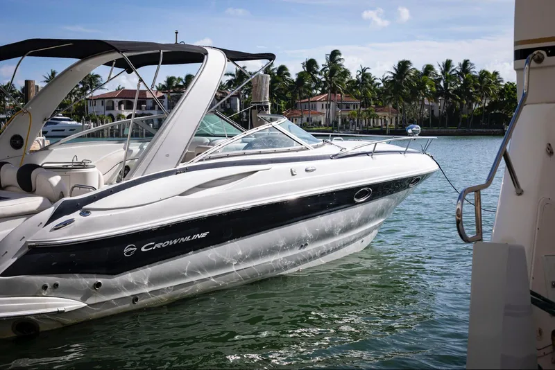 Slide: The Image of 2006 Crownline 320 LS boat docked in a scenic waterfront location with palm trees. - 5