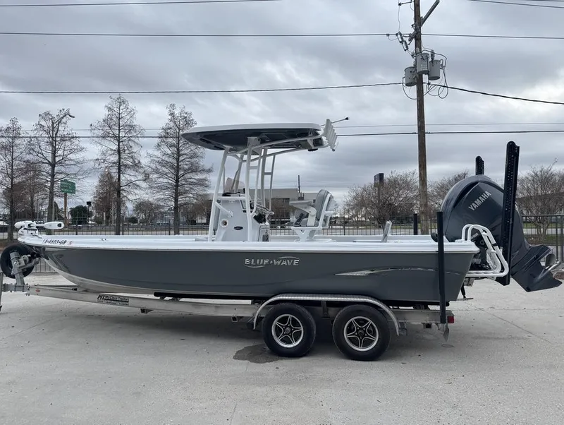 Slide: The Image of 2024 Blue Wave 2400 PURE BAY boat on trailer, side view, overcast sky. - 10
