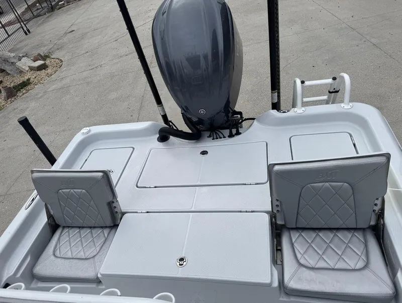 Slide: The Image of 2024 Blue Wave 2400 PURE BAY boat with gray seating and motor, docked on concrete. - 14