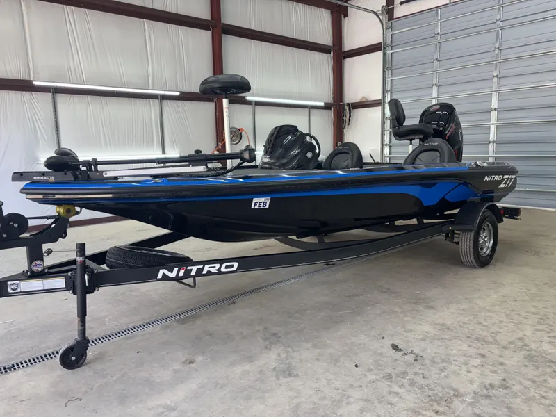 Slide: The Image of 2023 Nitro Z17 boat in a garage, blue and black design, on a trailer. - 13
