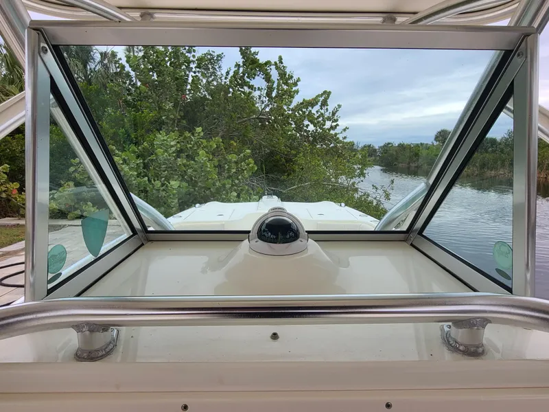Slide: The Image of 2008 World Cat 270 TE boat windshield view with lush greenery and waterway. - 15
