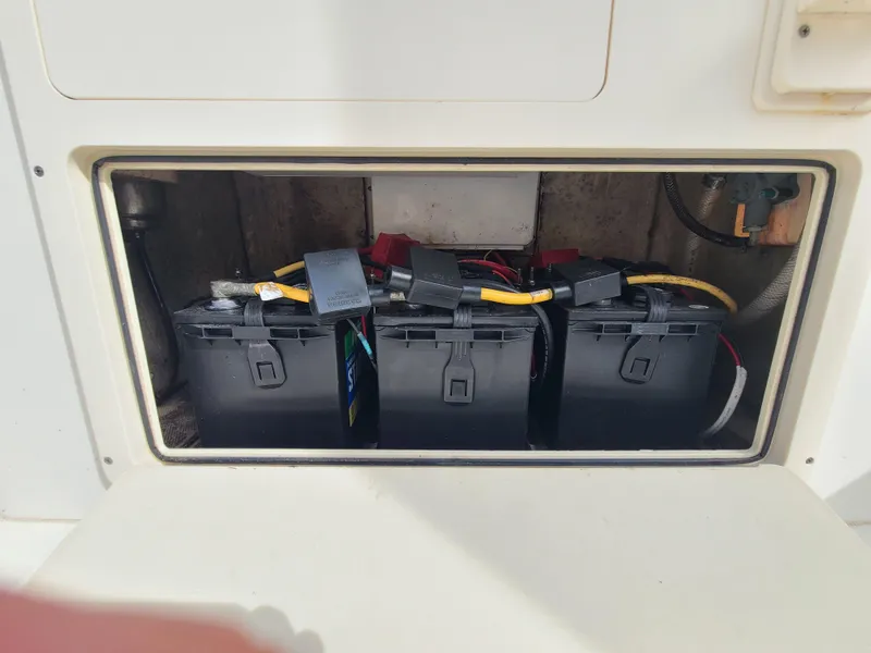 Slide: The Image of Battery compartment of a 2008 World Cat 270 TE boat, showing three batteries. - 34