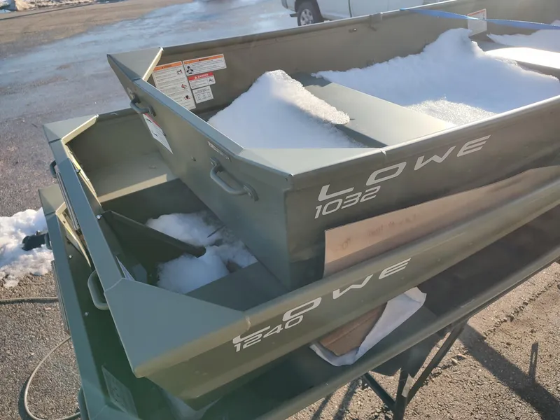 Slide: The Image of Stacked Lowe Jon boats with snow, models 1032 and 1240, on a sunny day. - 11